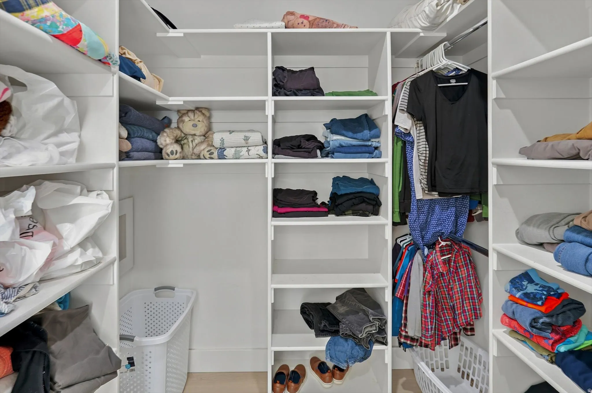 Custom closet system with white shelving, integrated hanging rods, and ample storage compartments