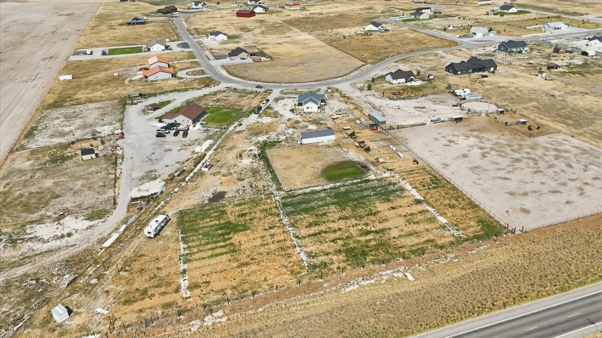 Expansive property featuring multiple structures, open land, and a gravel driveway