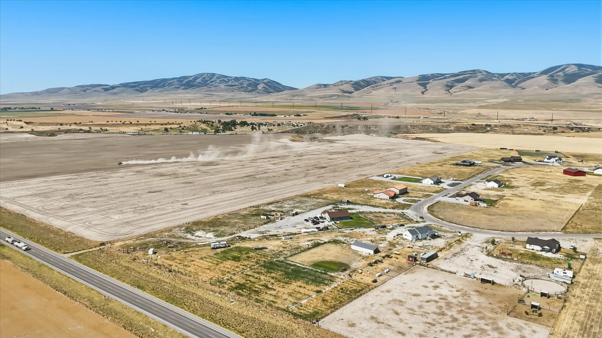 Aerial perspective showcasing extensive agricultural fields with distant mountains