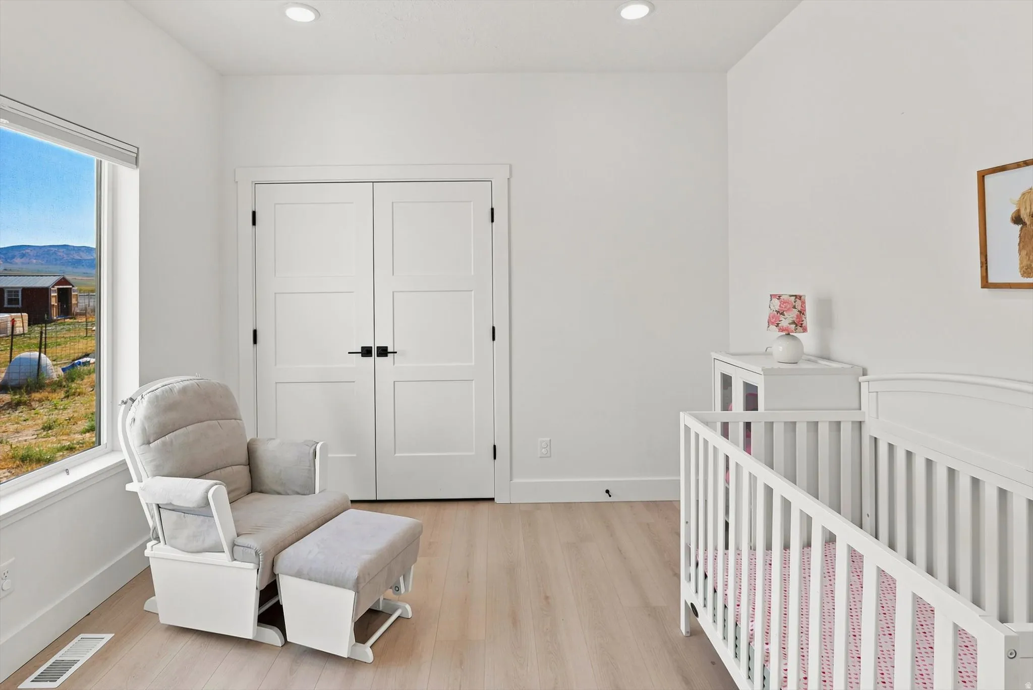 Bright interior space featuring light wood-finish flooring, recessed lighting, and a large window