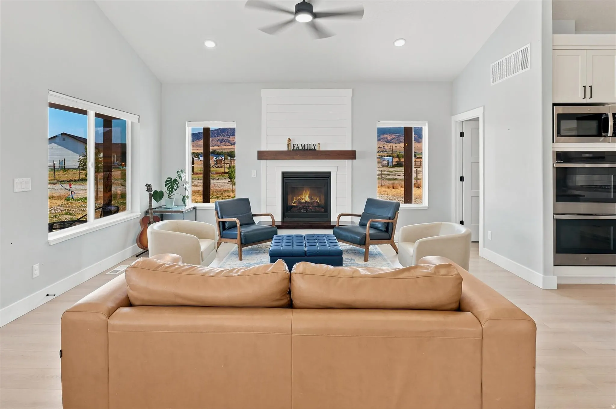 Open-concept living space featuring light wood-finish flooring, a contemporary ceiling fan, and recessed lighting