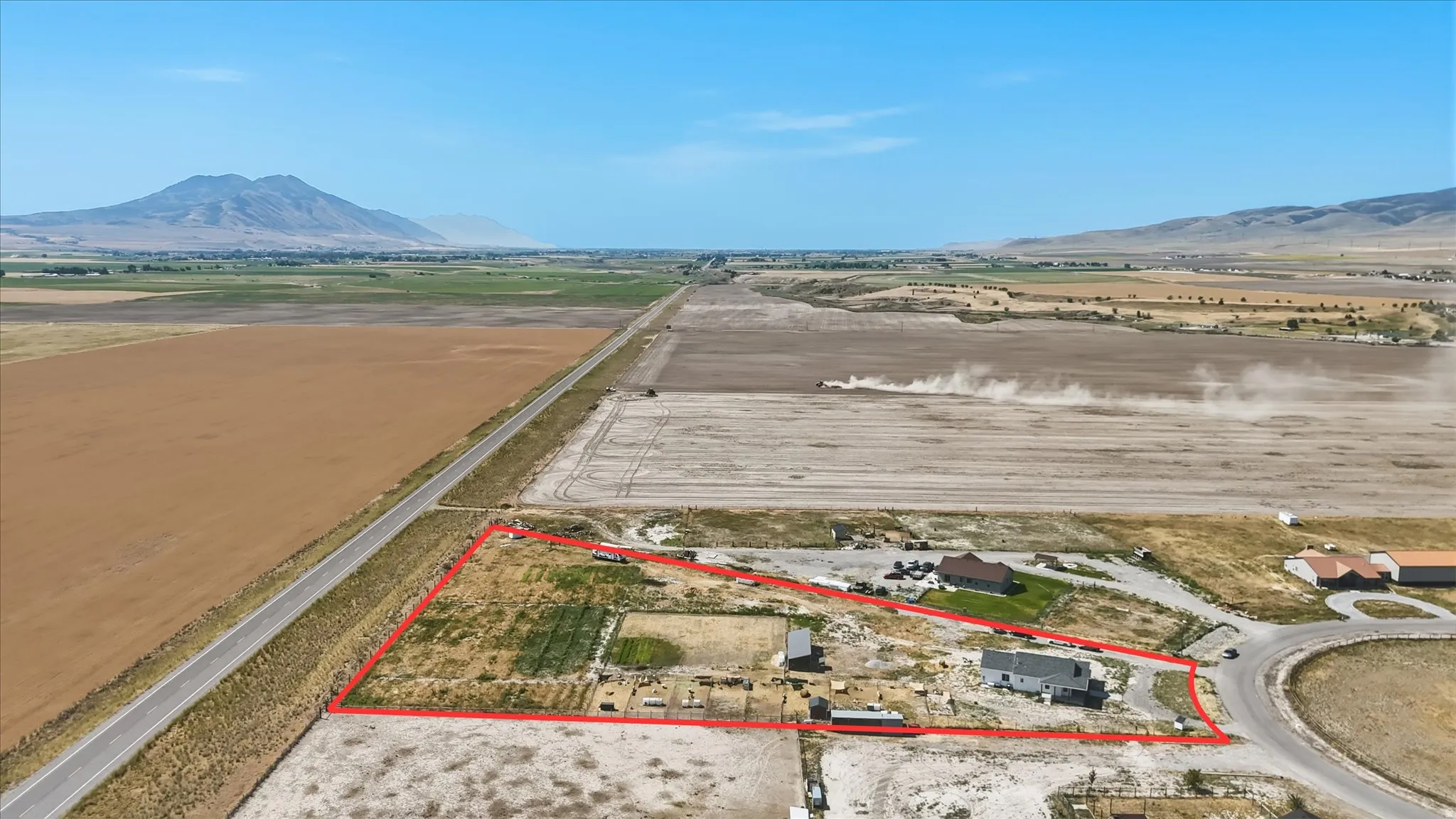 Expansive rural property featuring a single-story residence, multiple outbuildings, and extensive open land