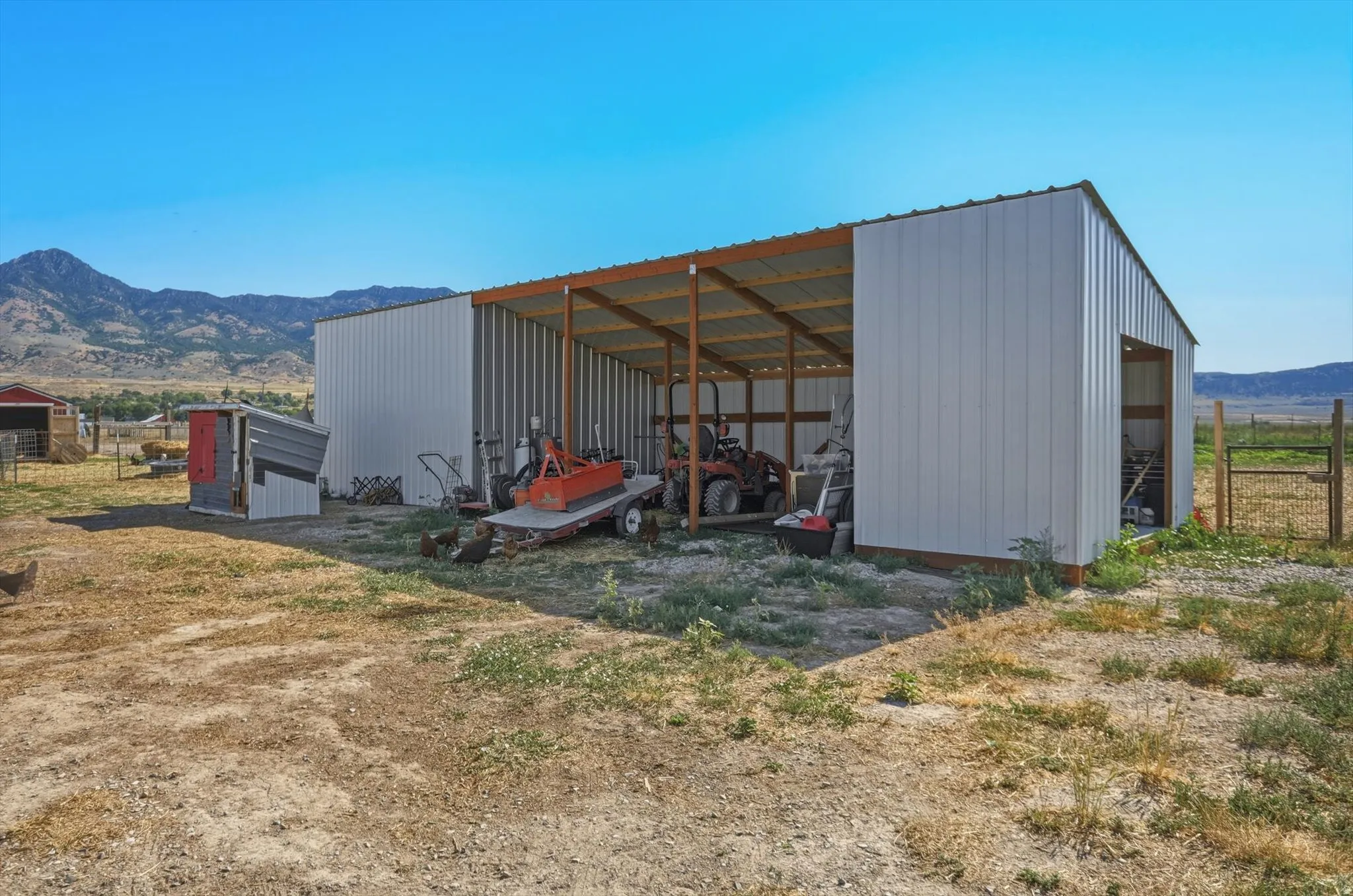 Large metal utility structure featuring an open-sided shed and an enclosed storage area