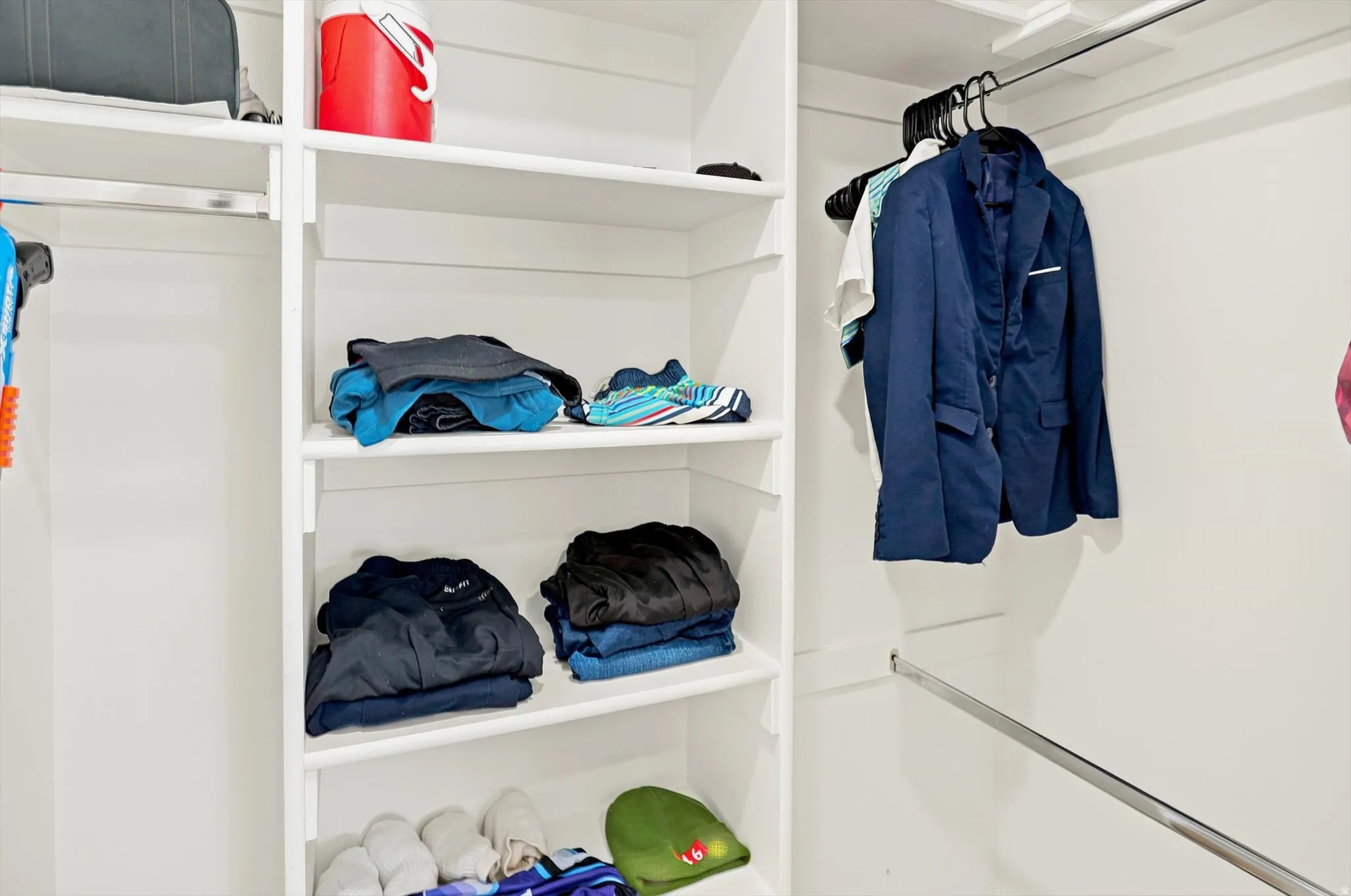Built-in closet system featuring white shelving and chrome hanging rods