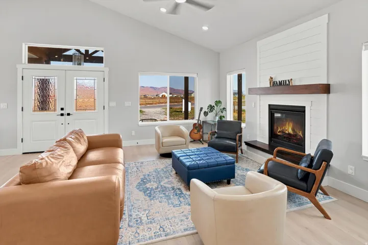 Living area featuring light wood-finish flooring and a vaulted ceiling with a ceiling fan