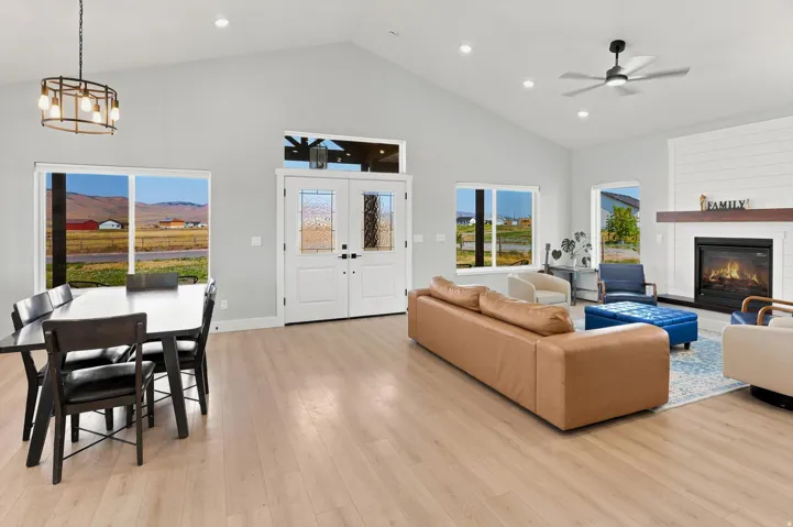 Open-concept living space featuring vaulted ceilings, light wood-finish flooring, and recessed lighting