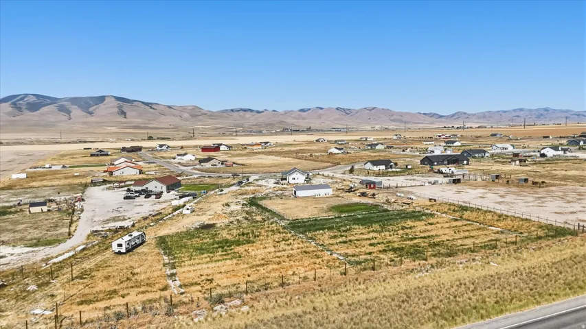 Expansive rural landscape featuring scattered residences and undeveloped land with a distant mountain range backdrop