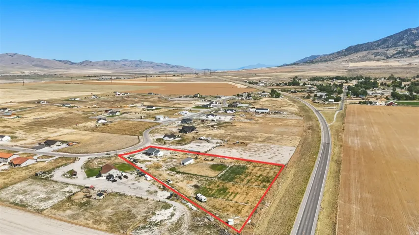 Expansive land parcel featuring clear boundaries, a partial road frontage, and a distant mountain backdrop
