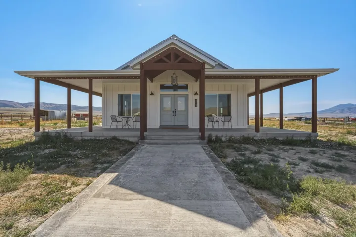 White board-and-batten exterior with a covered porch extending the full width of the facade