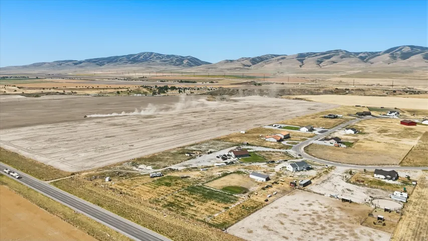 Aerial perspective showcasing extensive agricultural fields with distant mountains