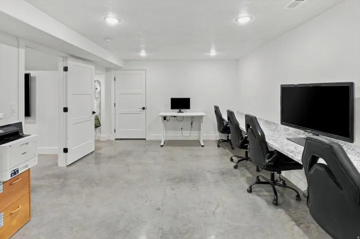 Expansive room featuring concrete-finish flooring, recessed lighting, white walls, and white trim
