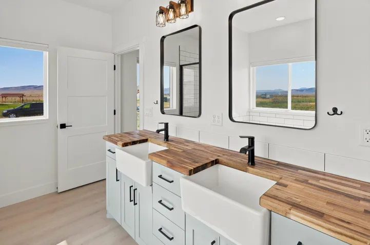 Dual farmhouse sinks set into a wood-finish countertop, complemented by light blue cabinetry