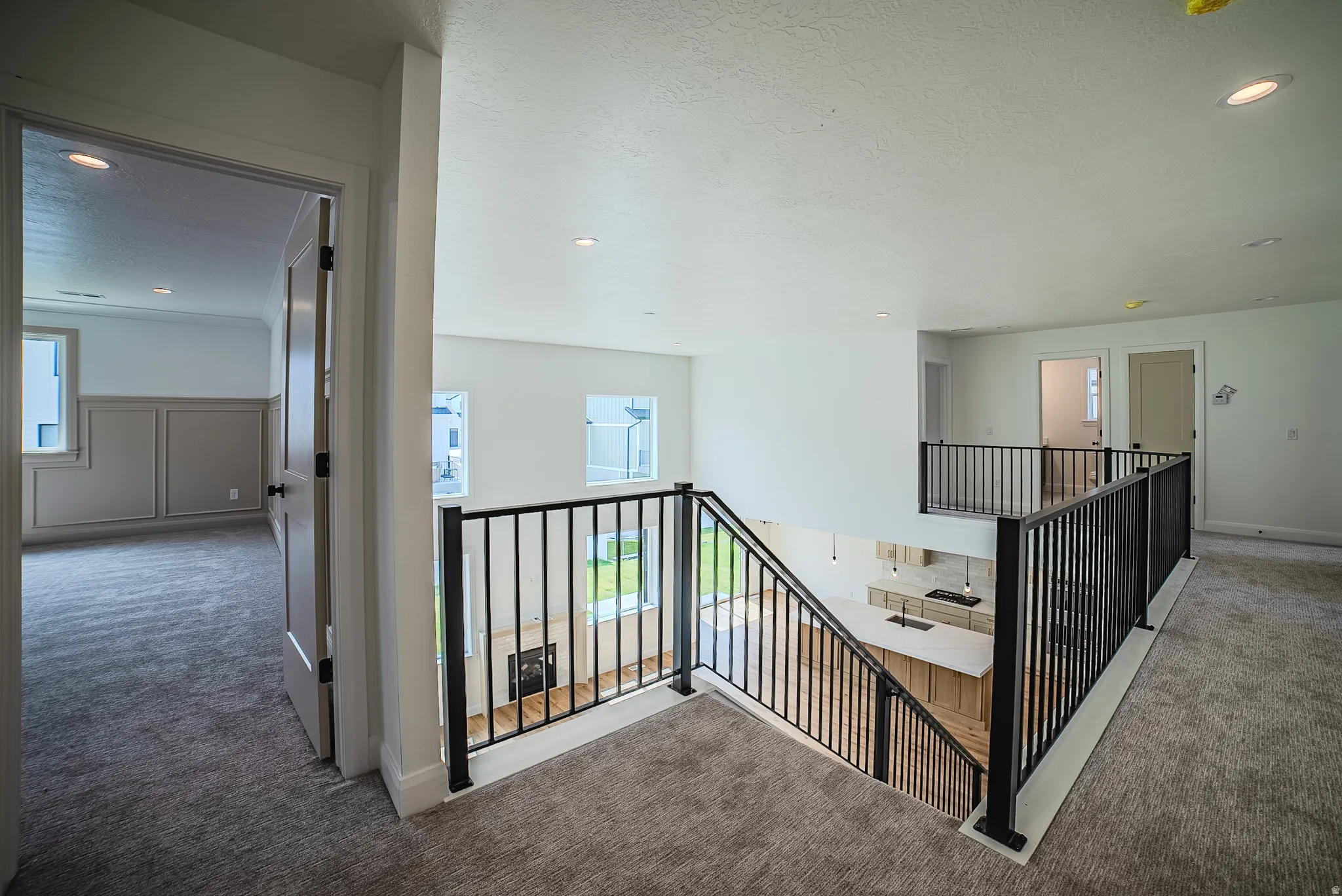 Upper-level landing with carpet flooring and black metal railings