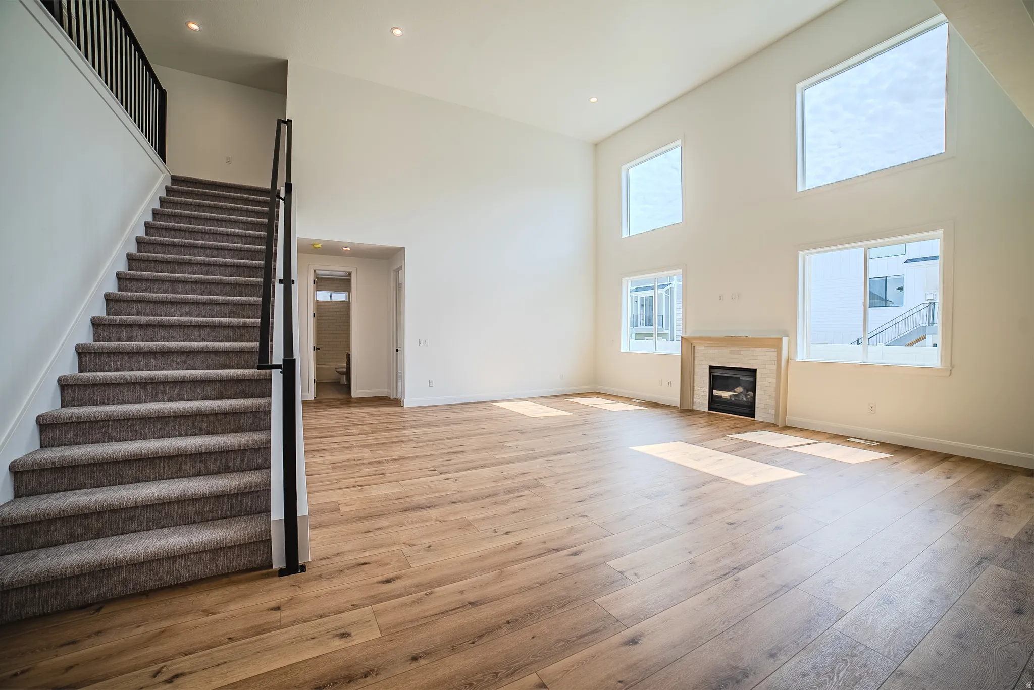 Expansive living area featuring soaring ceilings and wood-finish flooring