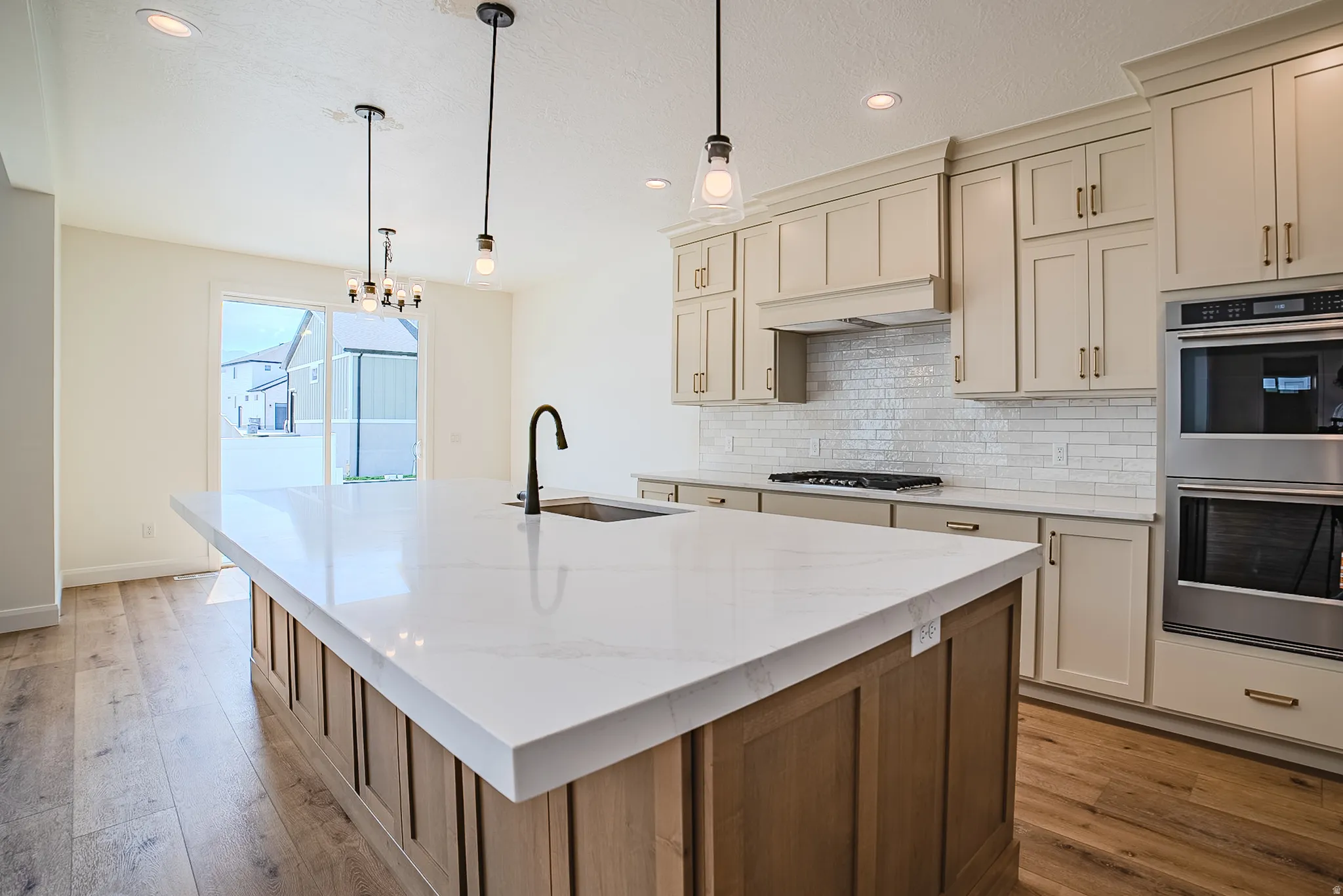 Kitchen featuring a large central island with a built-in sink and a matte black faucet