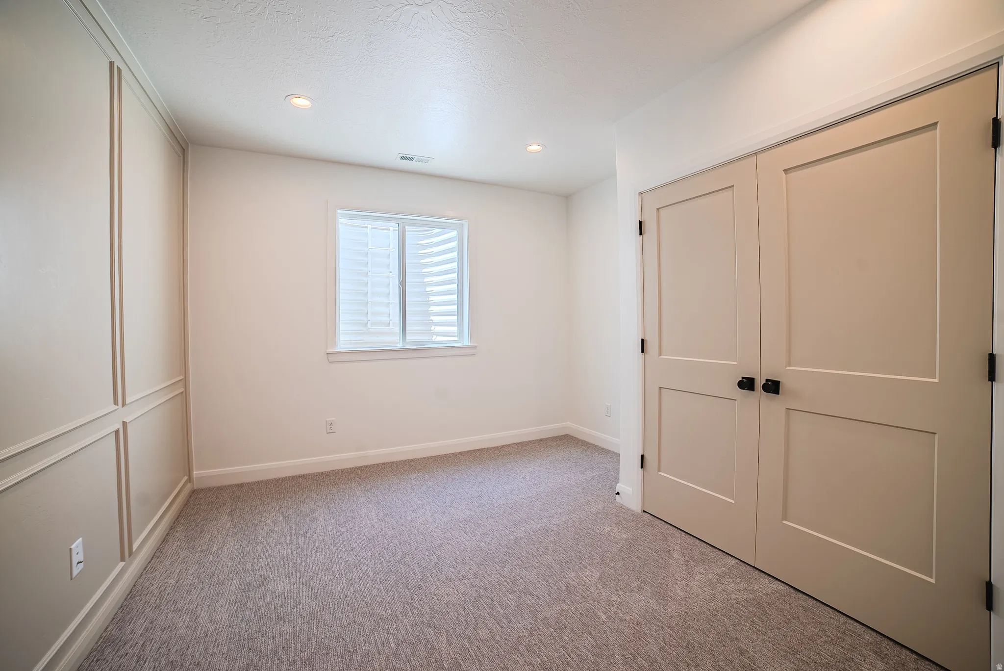 Room featuring neutral-toned textured carpet and recessed lighting