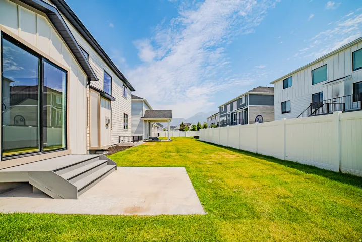Expansive green lawn with a white privacy fence