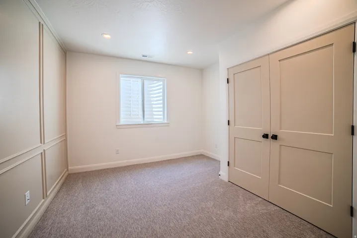 Room featuring neutral-toned textured carpet and recessed lighting
