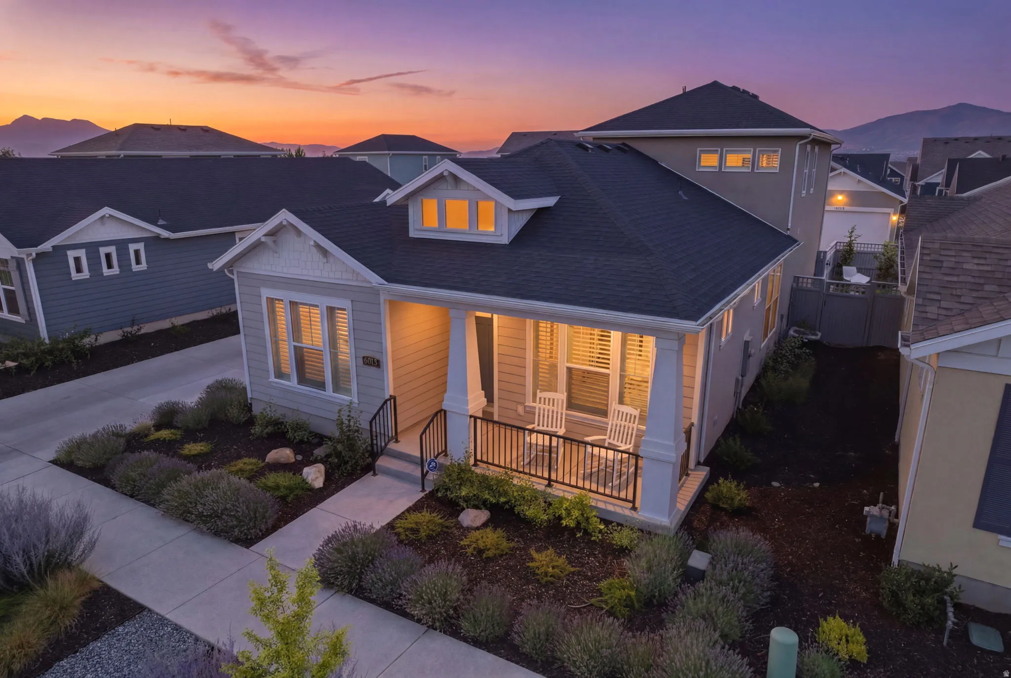 Single-story residence featuring a covered front porch, dormer window, and dark shingle roof