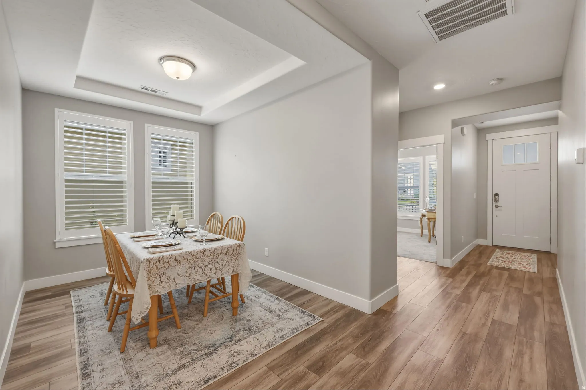 Dining area featuring LVP flooring and a coffered ceiling with a flush-mount light fixture.