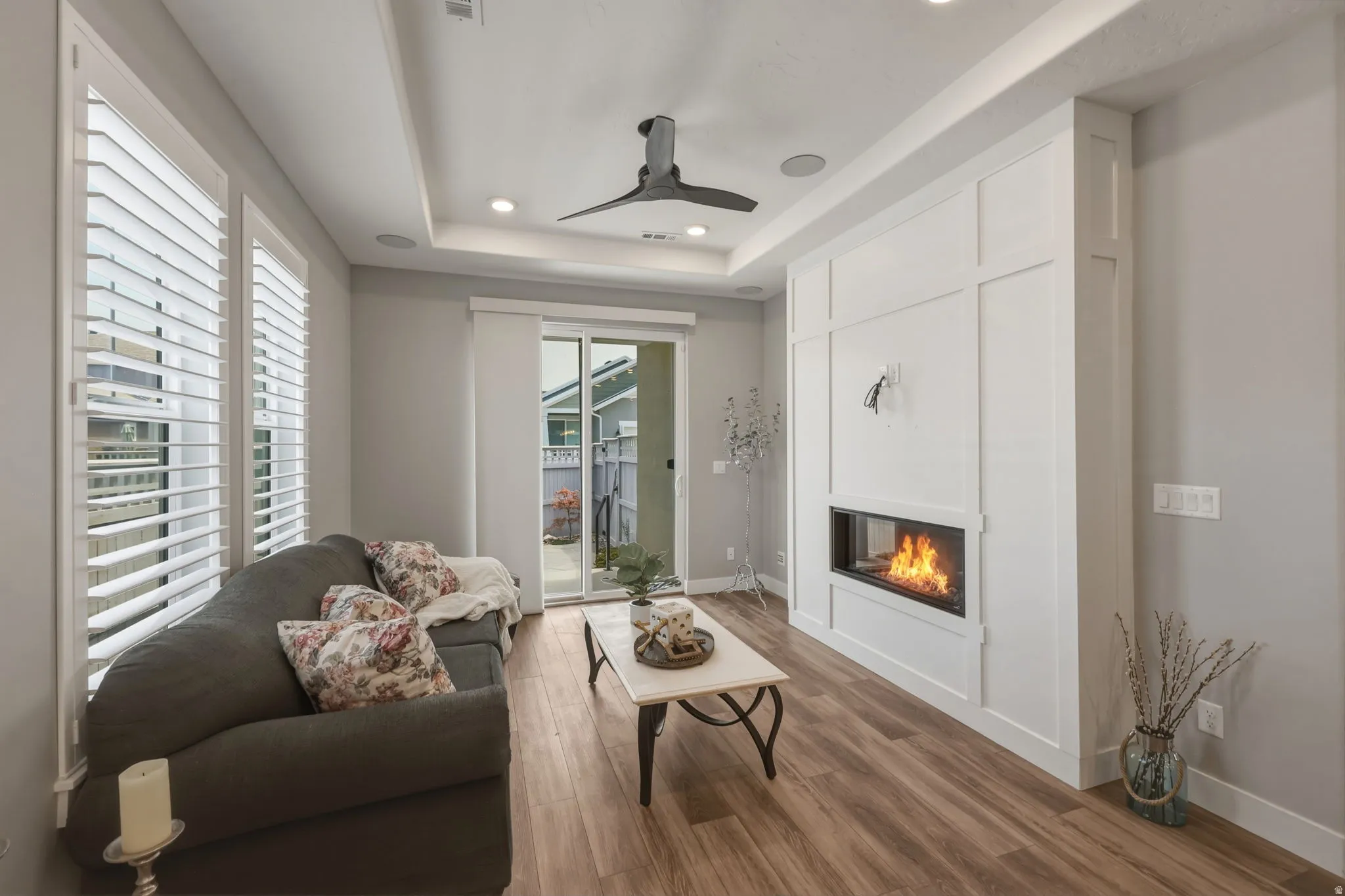 Living area featuring LVP flooring, a floor-to-ceiling accent wall with wainscoting detail and a built in fireplace.