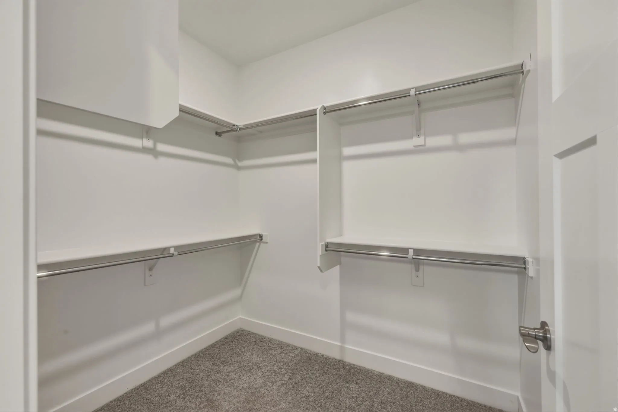 Prikmary suite walk-in closet with plenty of accessible storage.