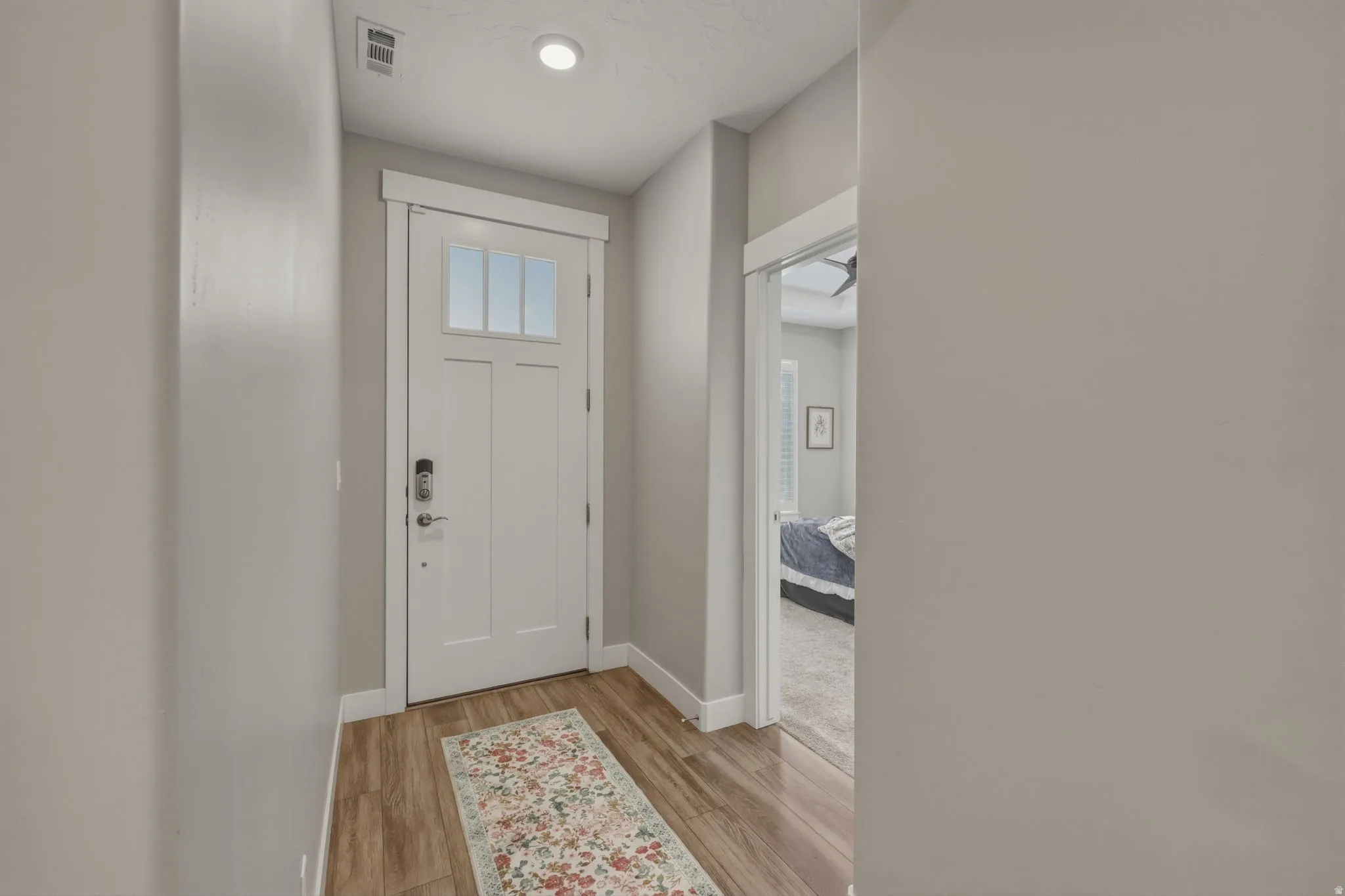 Entryway featuring wood-finish flooring, a white paneled door with upper glass inserts, and a recessed ceiling light