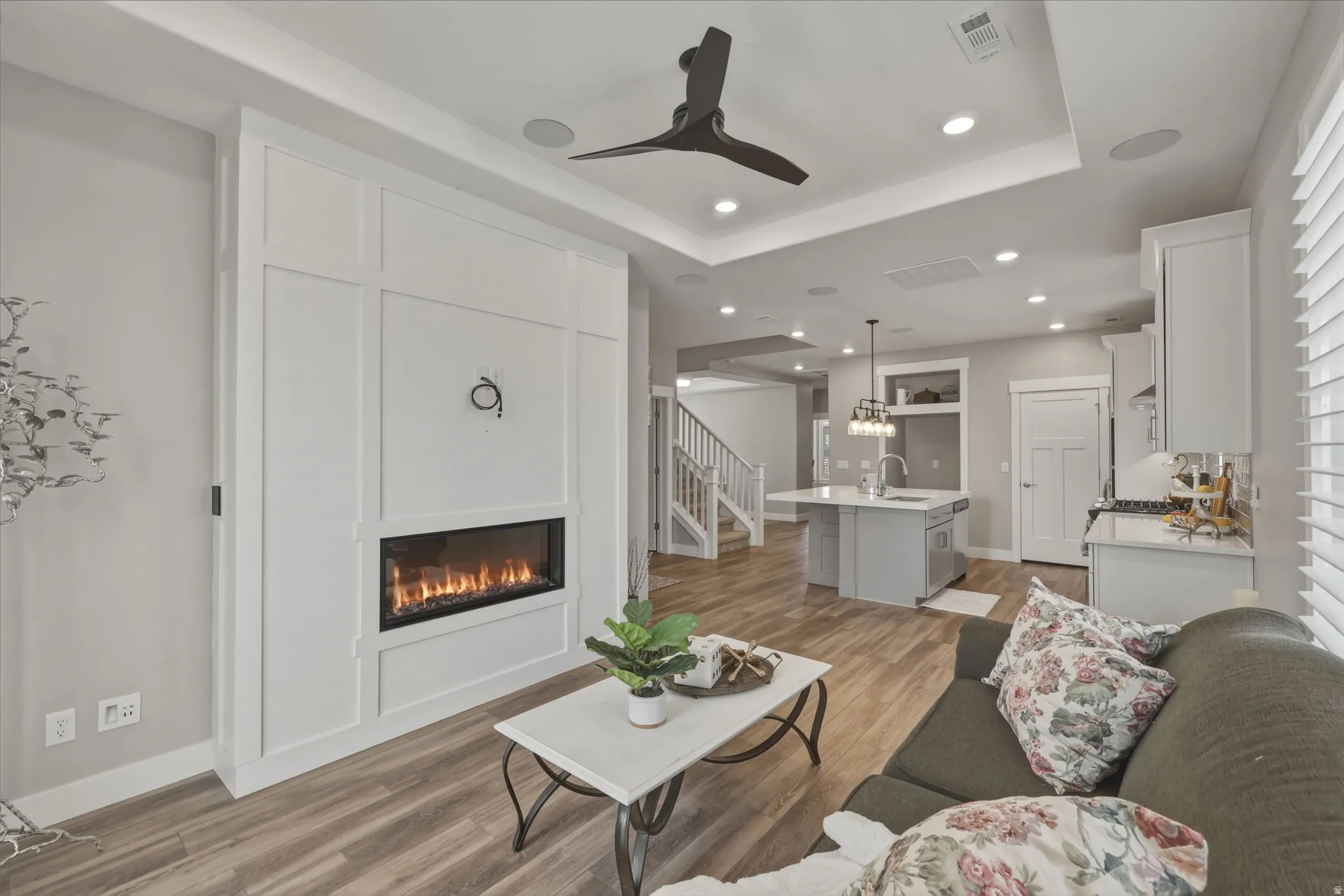Living area featuring LVP flooring, a floor-to-ceiling accent wall with wainscoting detail and a built in fireplace.