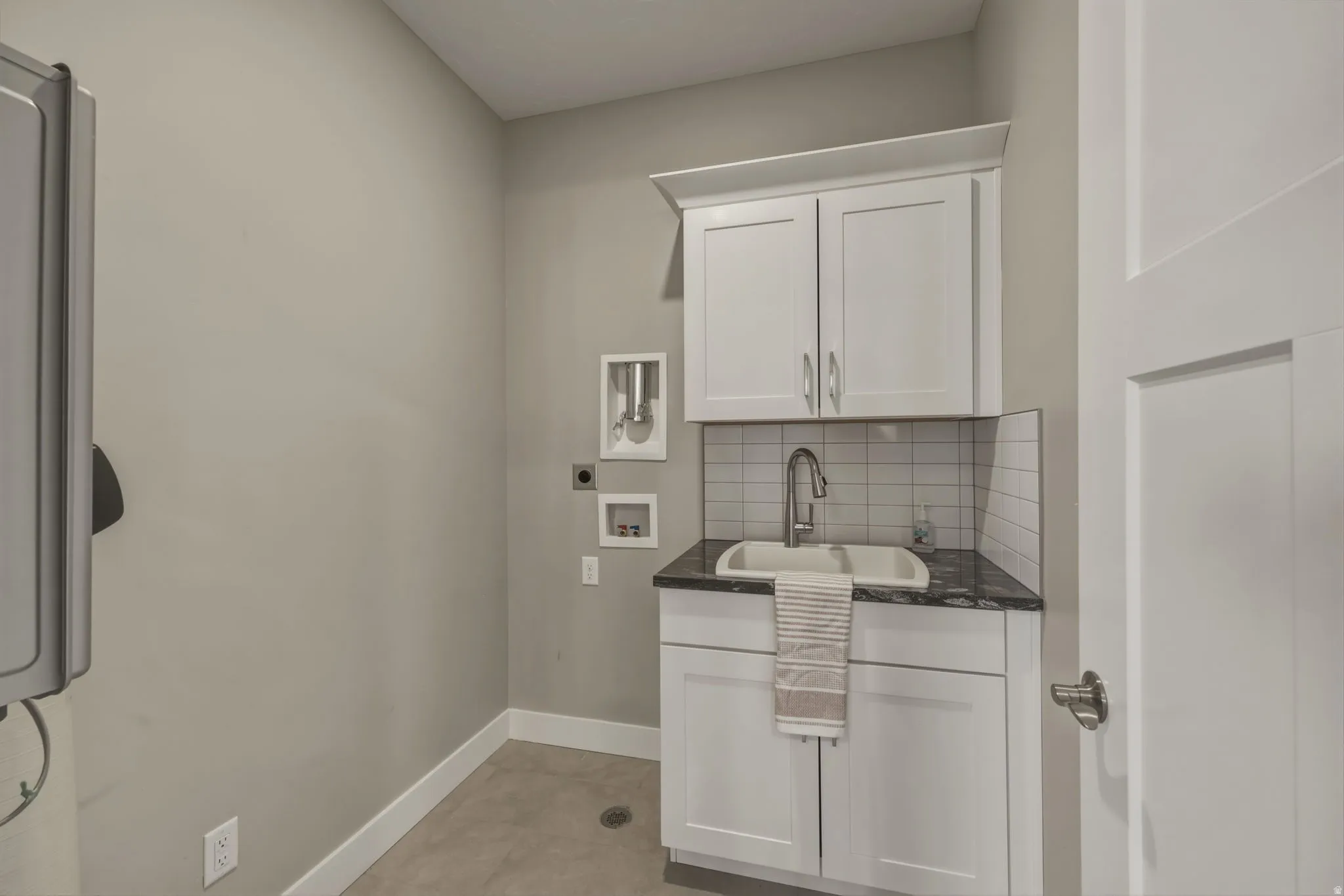 Laundry room with added custom. cabinetry and sink.