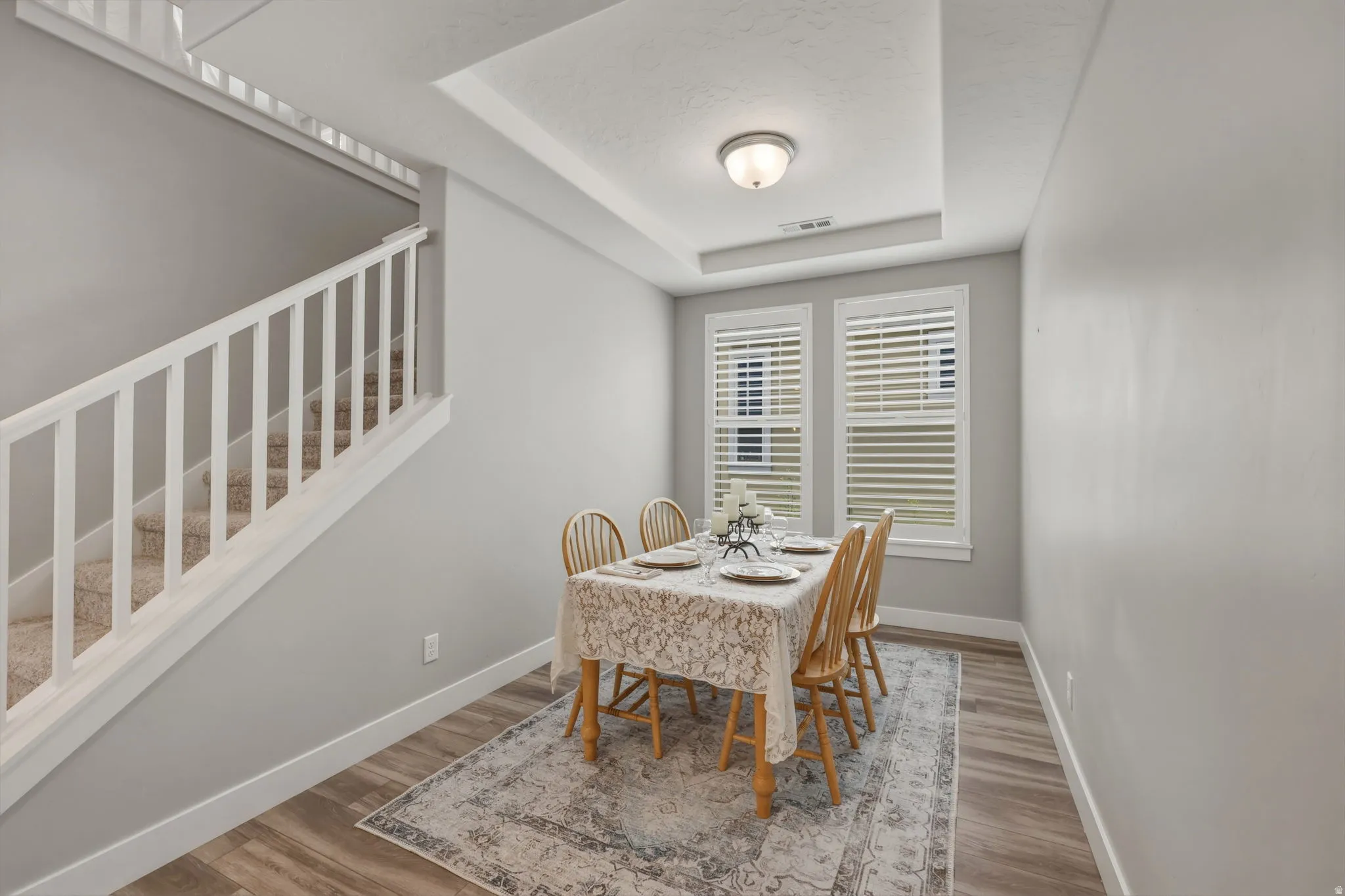 Dining area featuring LVP flooring and a coffered ceiling with a flush-mount light fixture.