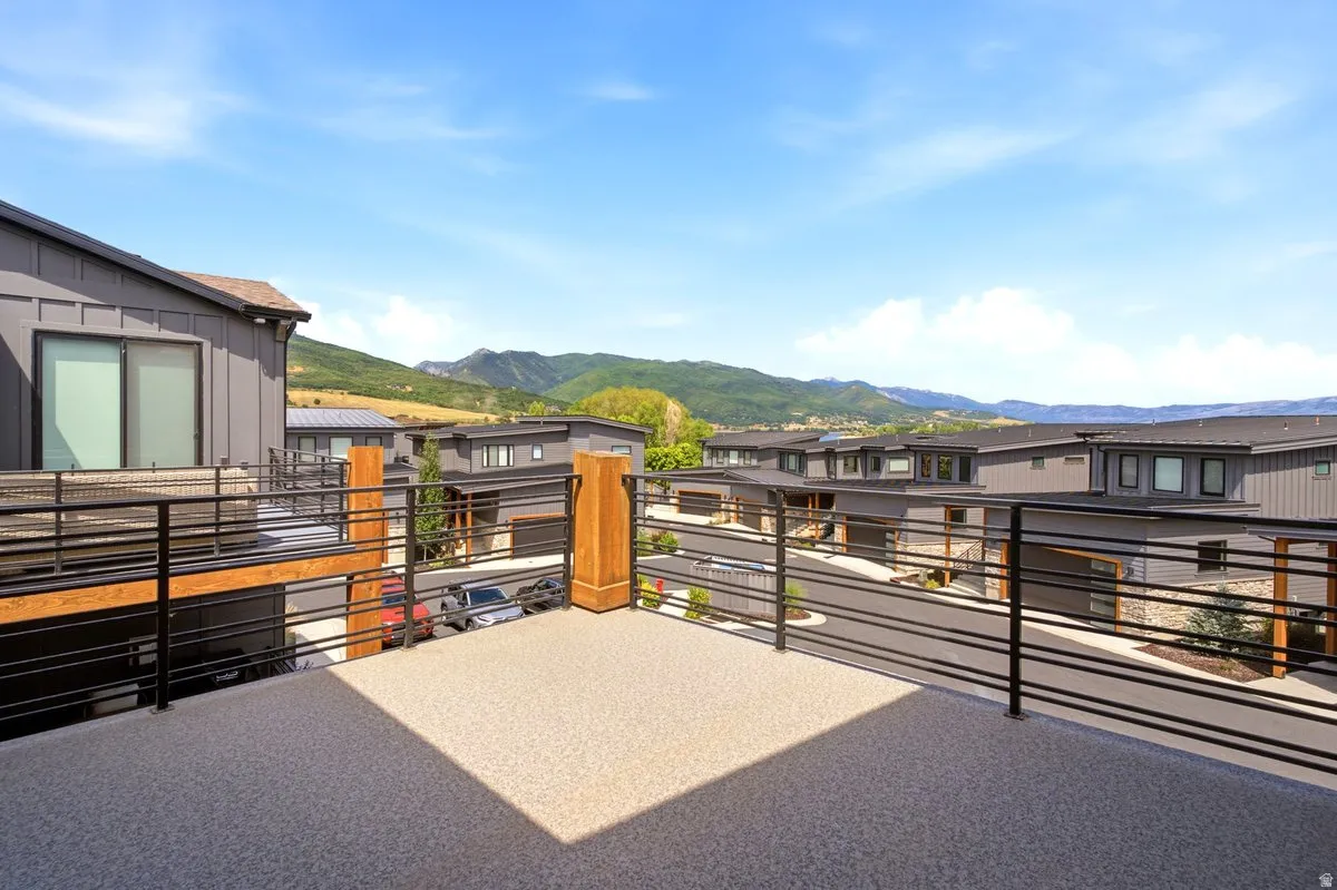 Spacious rooftop deck featuring a textured surface and contemporary horizontal metal railings