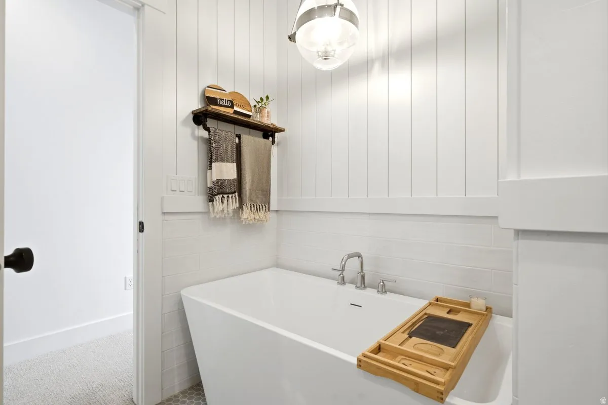Freestanding soaking tub featuring a deck-mounted faucet with brushed nickel finish