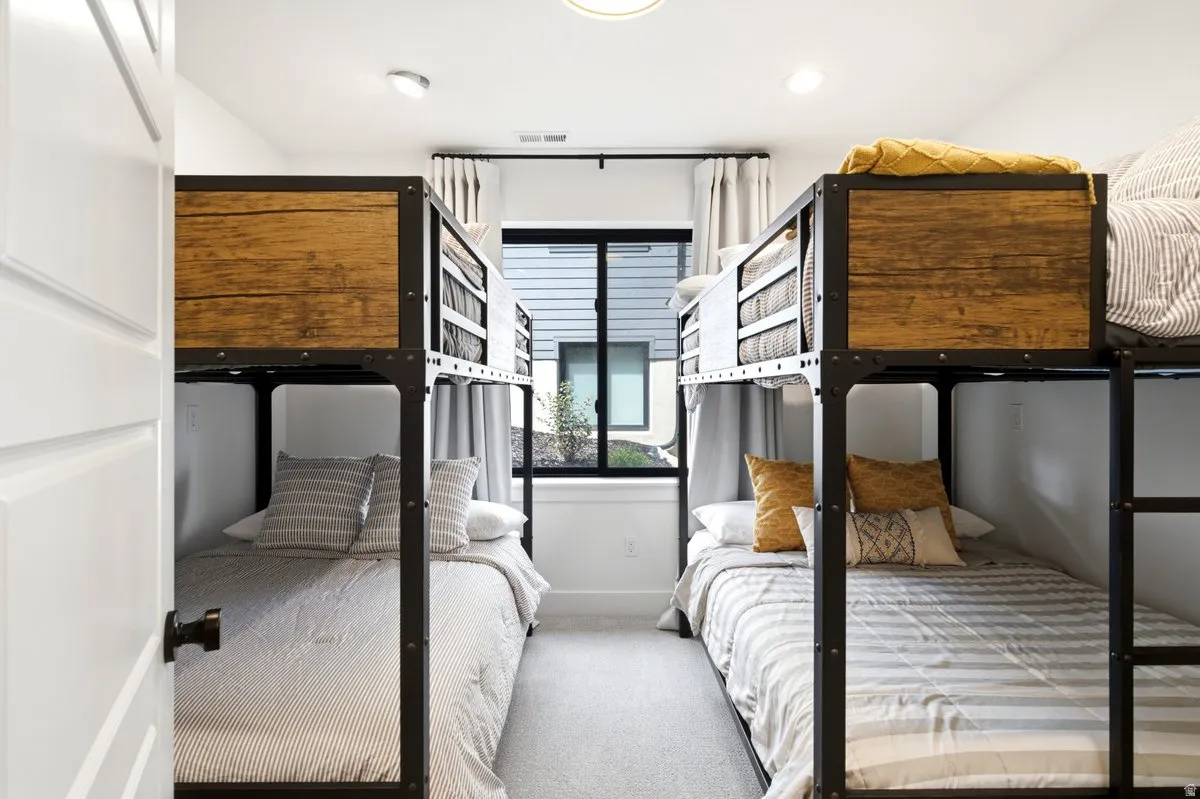 Bedroom with two industrial-style bunk bed frames featuring wood-finish paneling and metal accents
