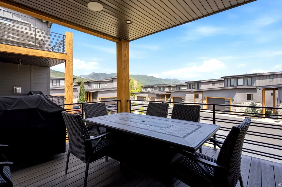 Covered outdoor deck with composite decking, black metal railings, and natural wood support beams
