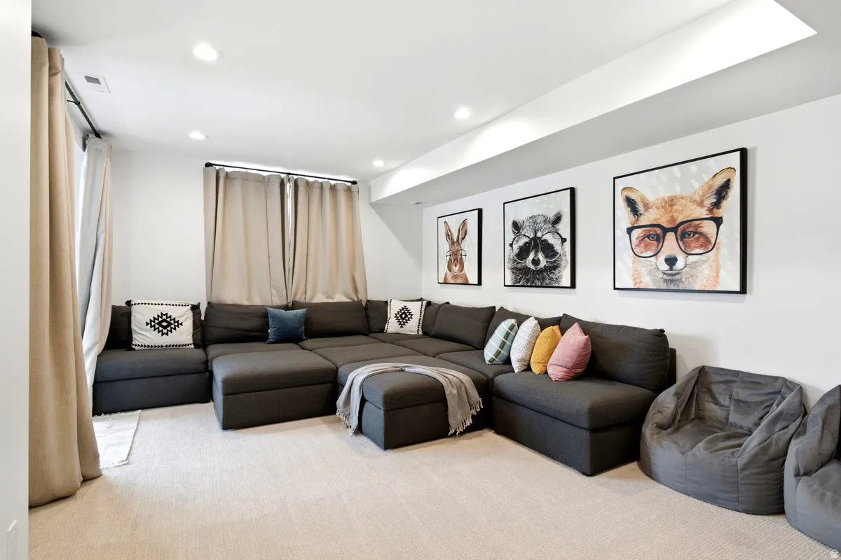 Spacious room featuring light-colored carpeting, recessed lighting, white walls, and window treatments