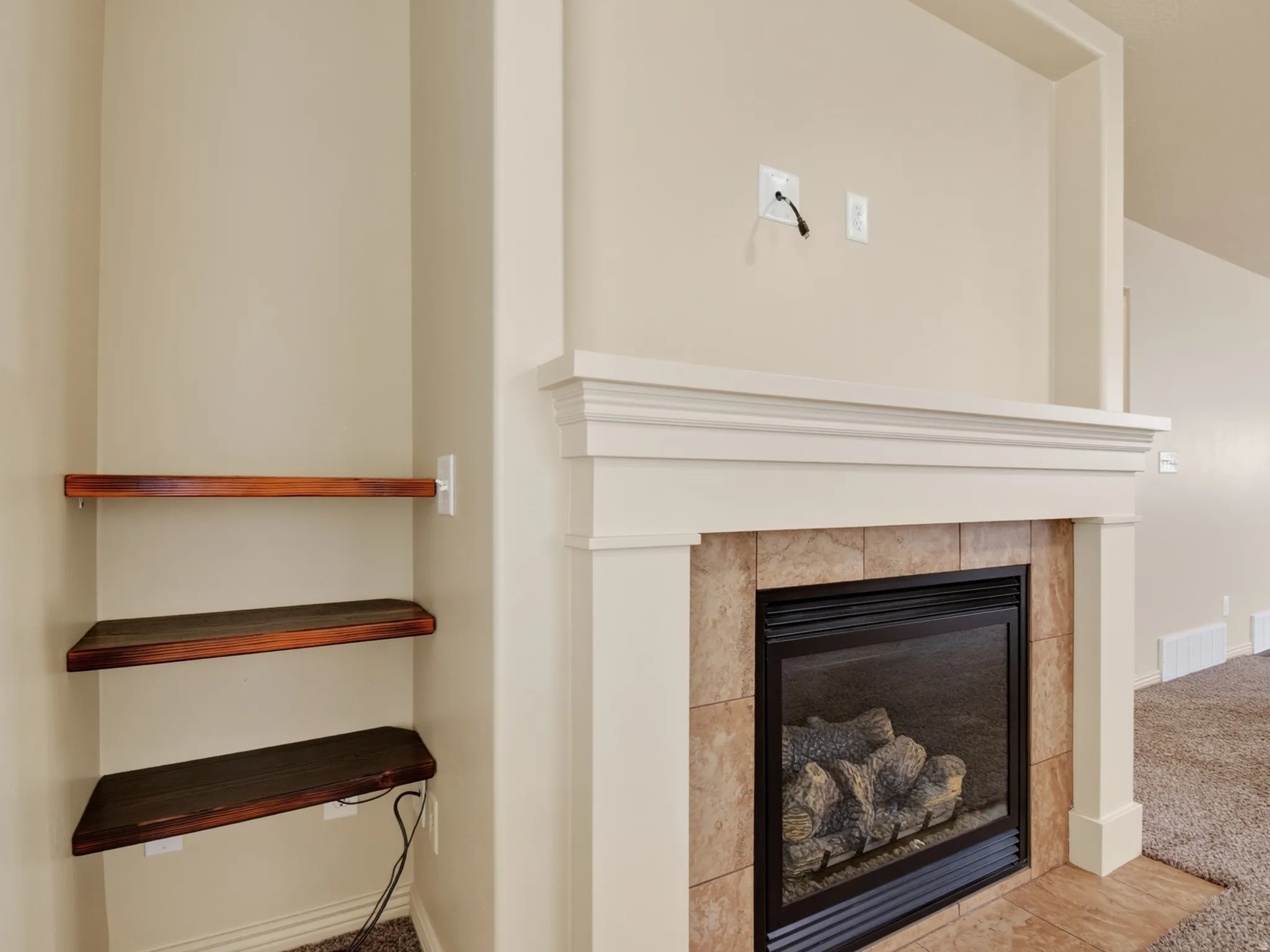 Built-in fireplace featuring a tile surround, hearth, and white mantelpiece