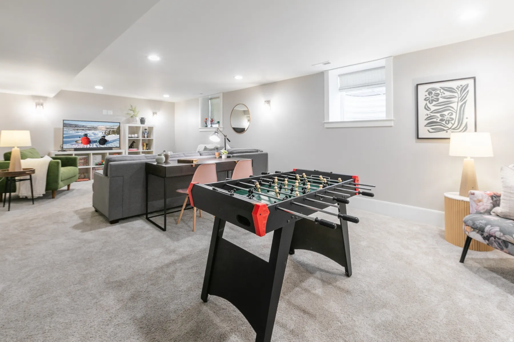 Spacious recreational area featuring light gray wall paint, recessed lighting, and light gray carpeted flooring