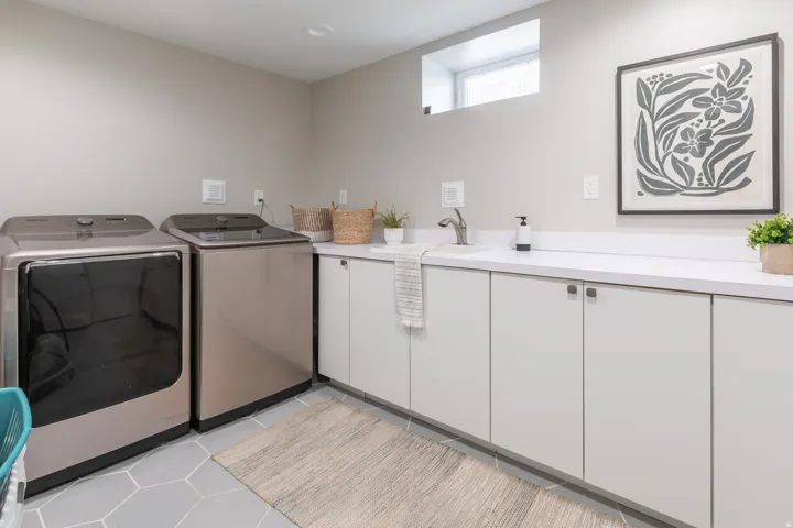 Laundry room with contemporary flat-panel cabinetry, a utility sink, and white countertop