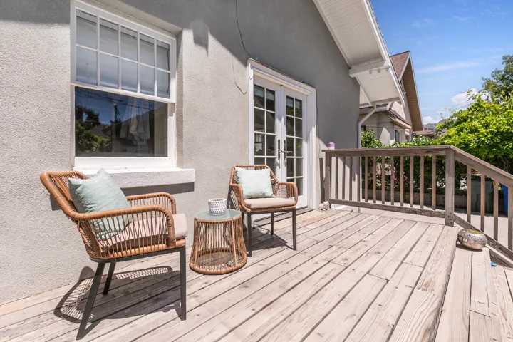 Outdoor deck featuring wood plank flooring, a wood railing, and a set of white French doors