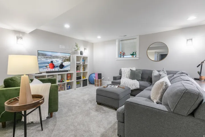Finished lower level featuring recessed lighting, plush carpeting, built-in shelving, and a bright window