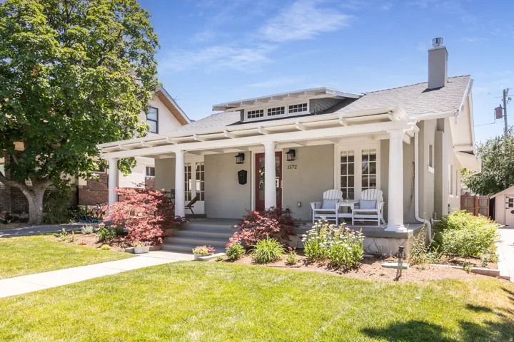 Stucco exterior with a covered porch featuring white columns