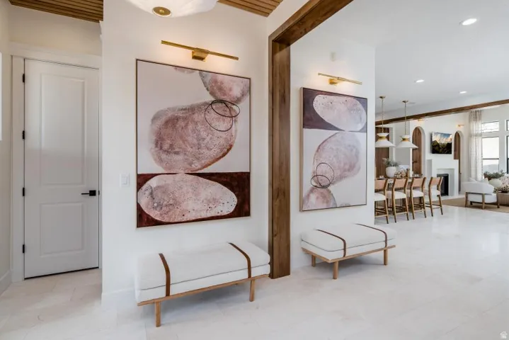 Bright, open foyer featuring exposed wood beams, recessed ceiling lighting, and polished concrete flooring