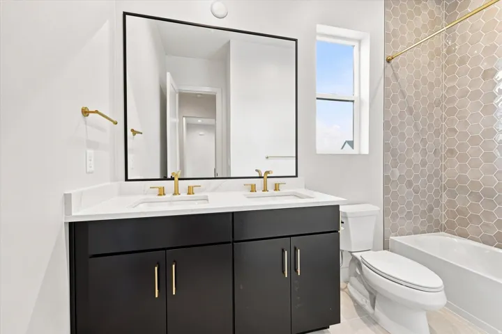 Dual vanity with integrated sinks, white countertop, and gold-finish fixtures
