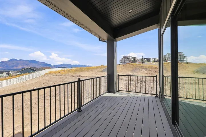 Covered outdoor deck with composite decking, black metal railings, and integrated overhead lighting
