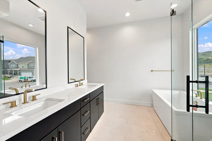 Dual vanity with rectangular sinks, gold-finish fixtures, and dark cabinetry