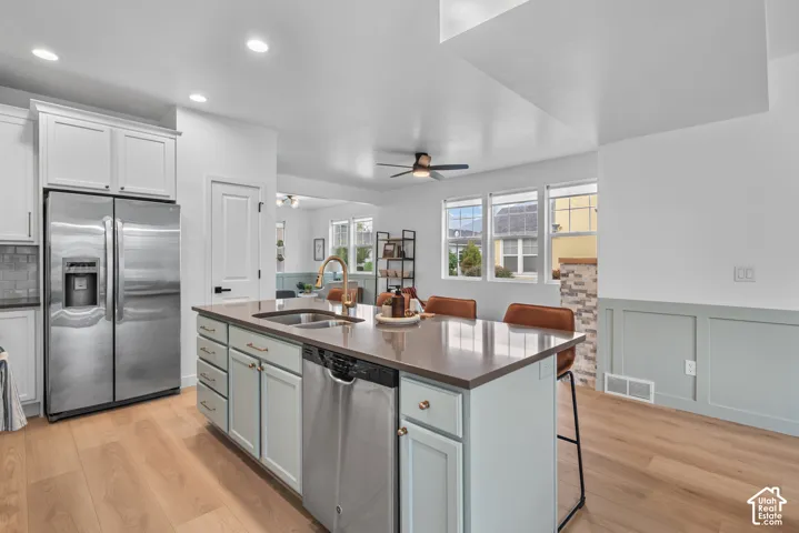 Modern kitchen featuring a central island with an undermount sink and integrated dishwasher