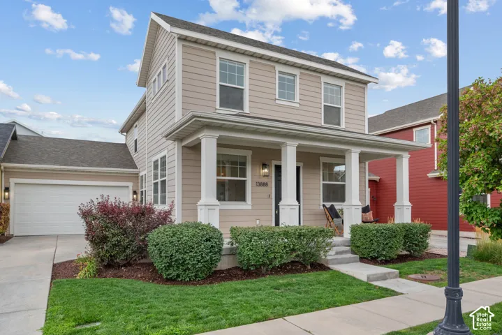 Two-story residence featuring light-colored siding and a covered front porch with white columns