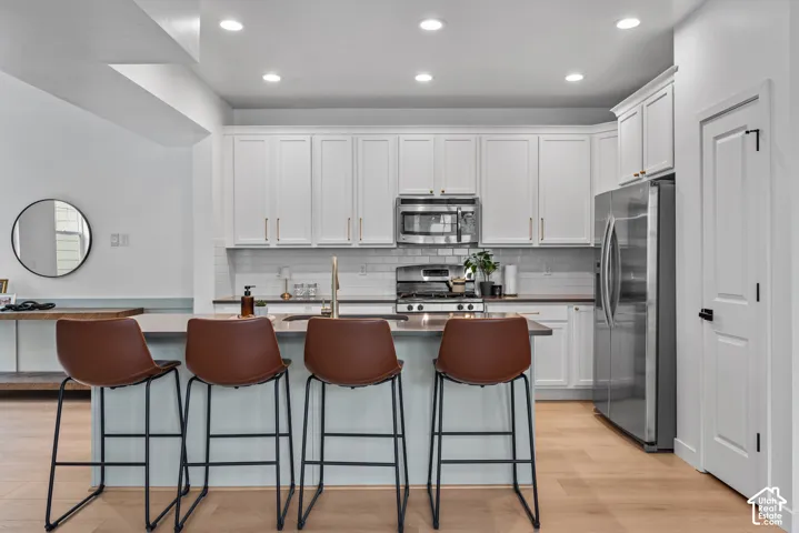 Modern kitchen featuring light wood-finish flooring and recessed lighting