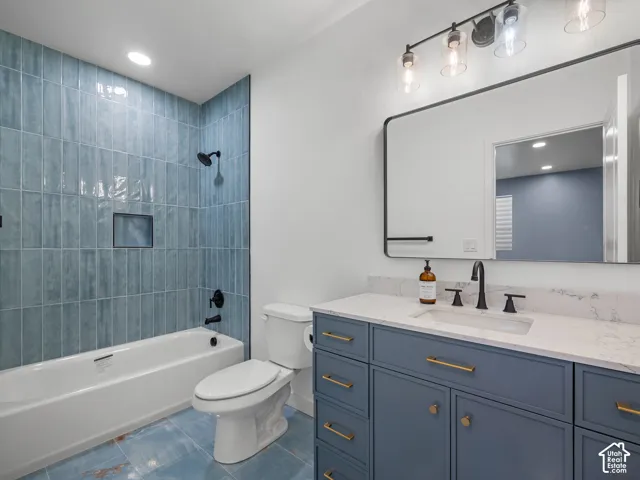 Contemporary bathroom featuring a blue tiled shower surround with a built-in niche, a white tub, and a white toilet