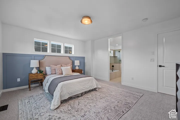 Carpeted bedroom featuring a blue wainscoting accent wall, three transom windows, and a flush-mount ceiling light fixture